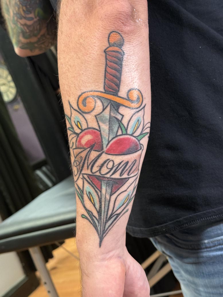 Knife through a heart with "MOM" tattoo