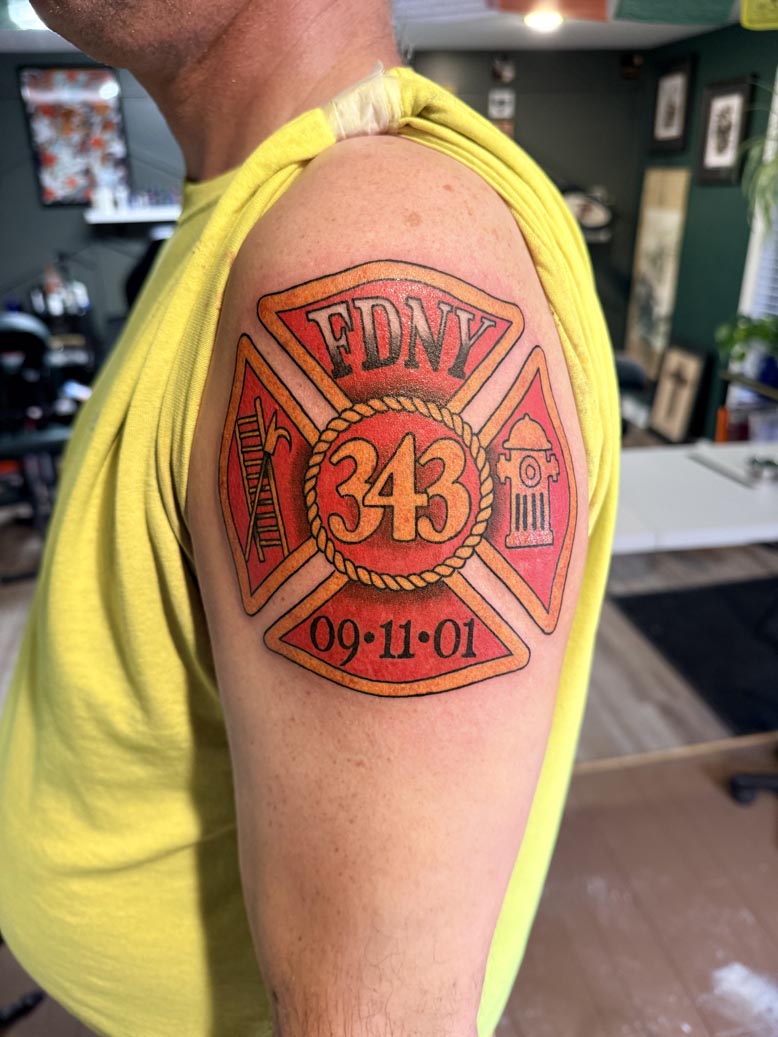 Red firefighter badge tattoo