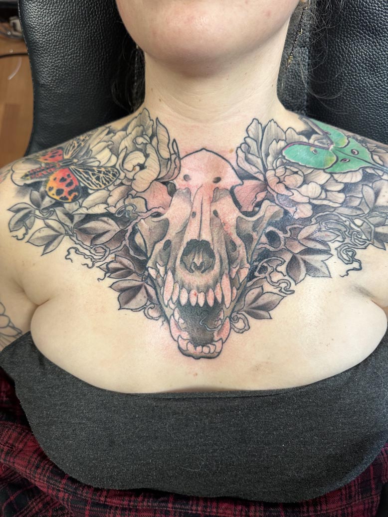 Skull and flowers chest tattoo