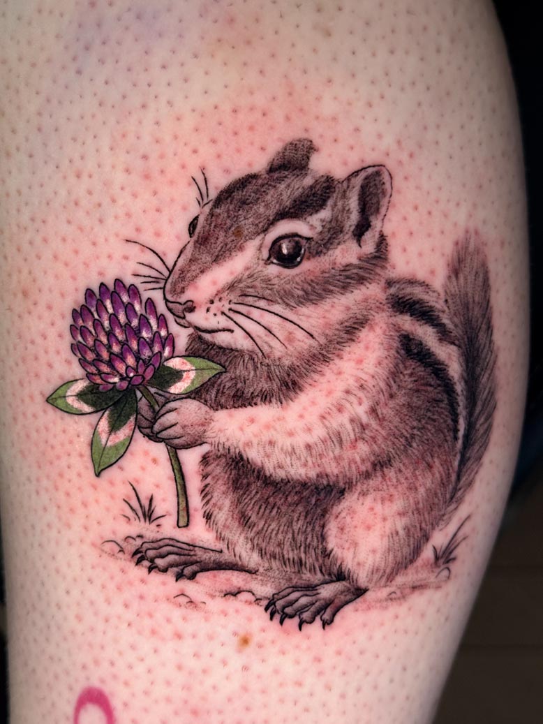 Chipmunk holding a purple clover tattoo