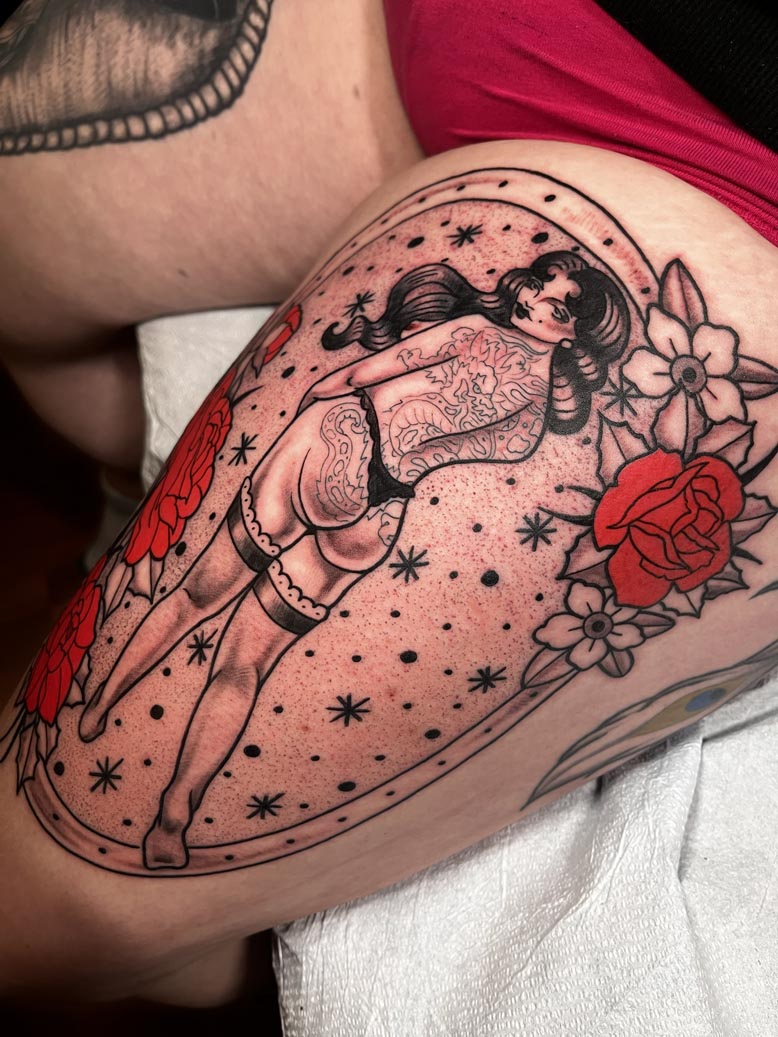 Pin up style thigh tattoo