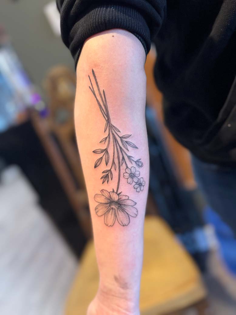 Black ink wild flower arm tattoo