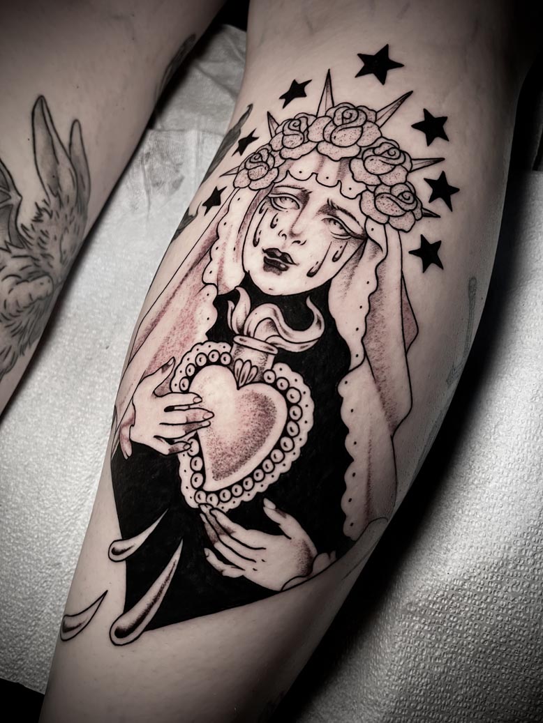 Black ink tattoo of a crying woman wearing a crown of flowers