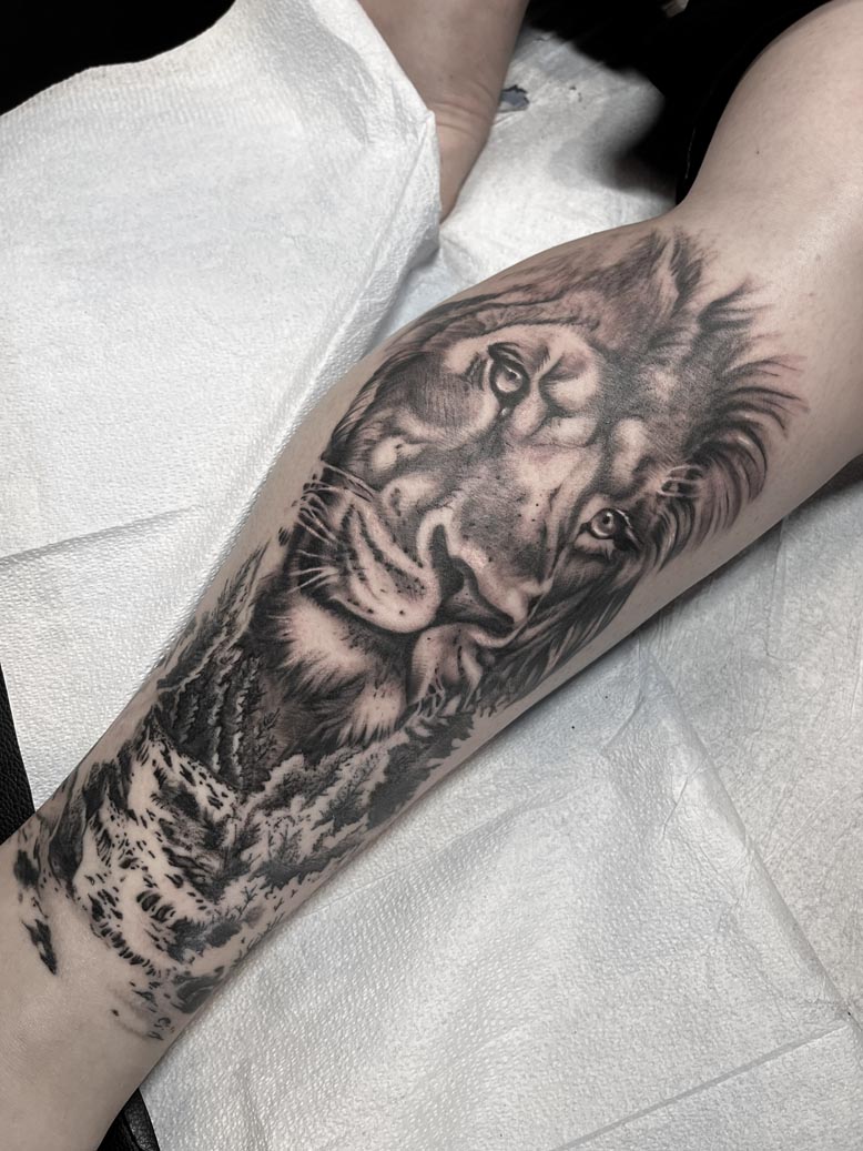 Black ink lion portrait tattoo