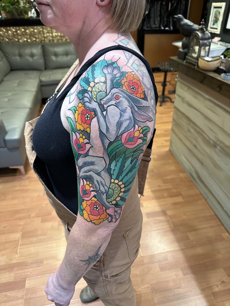 Colorful rabbit and flowers arm tattoo