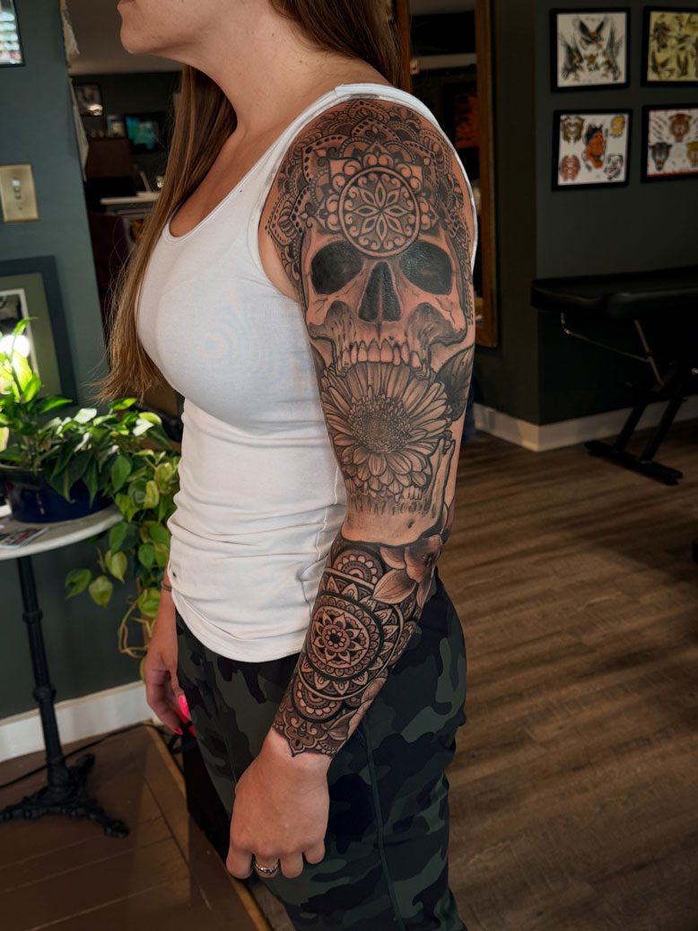 Tattoo arm sleeve with a skull at the top