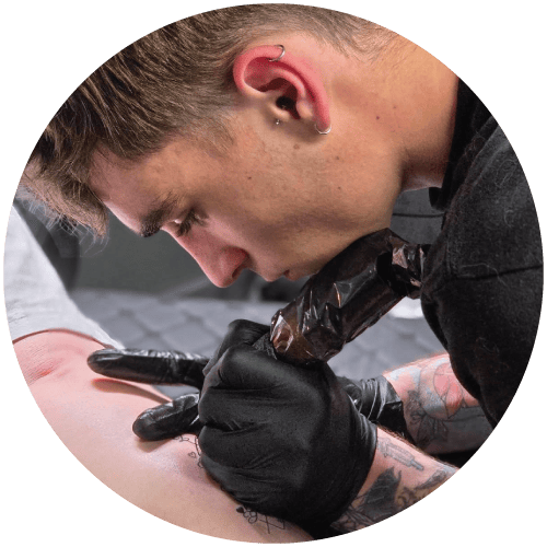 Taylor tattooing on a leg